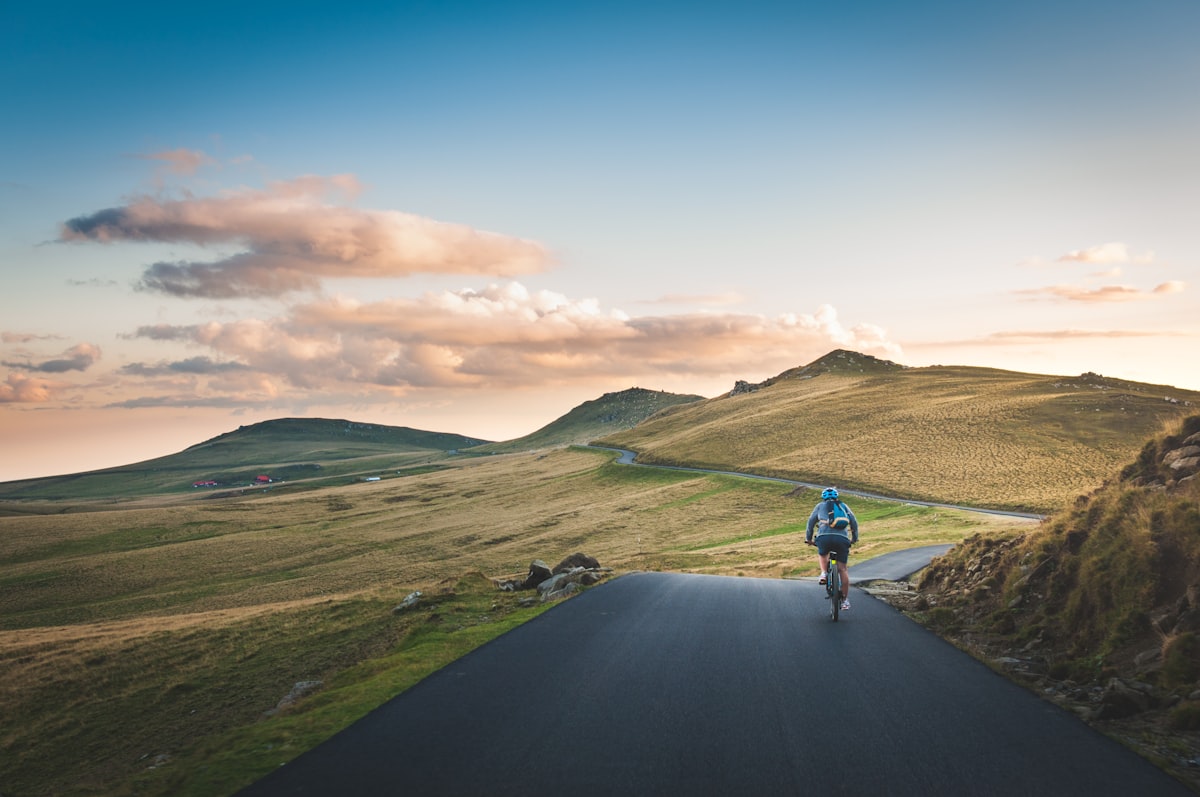 Fietser op een open weg bij zonsopgang