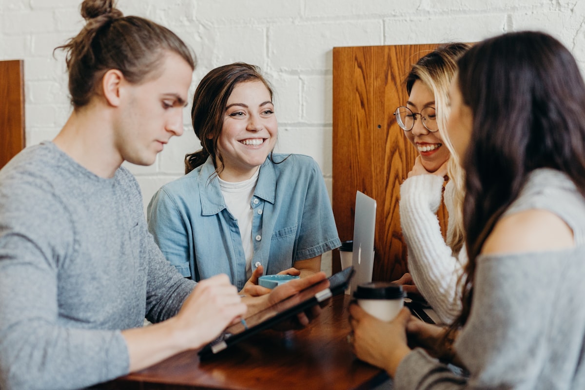 Collega's overleggen lachend rond een tafel